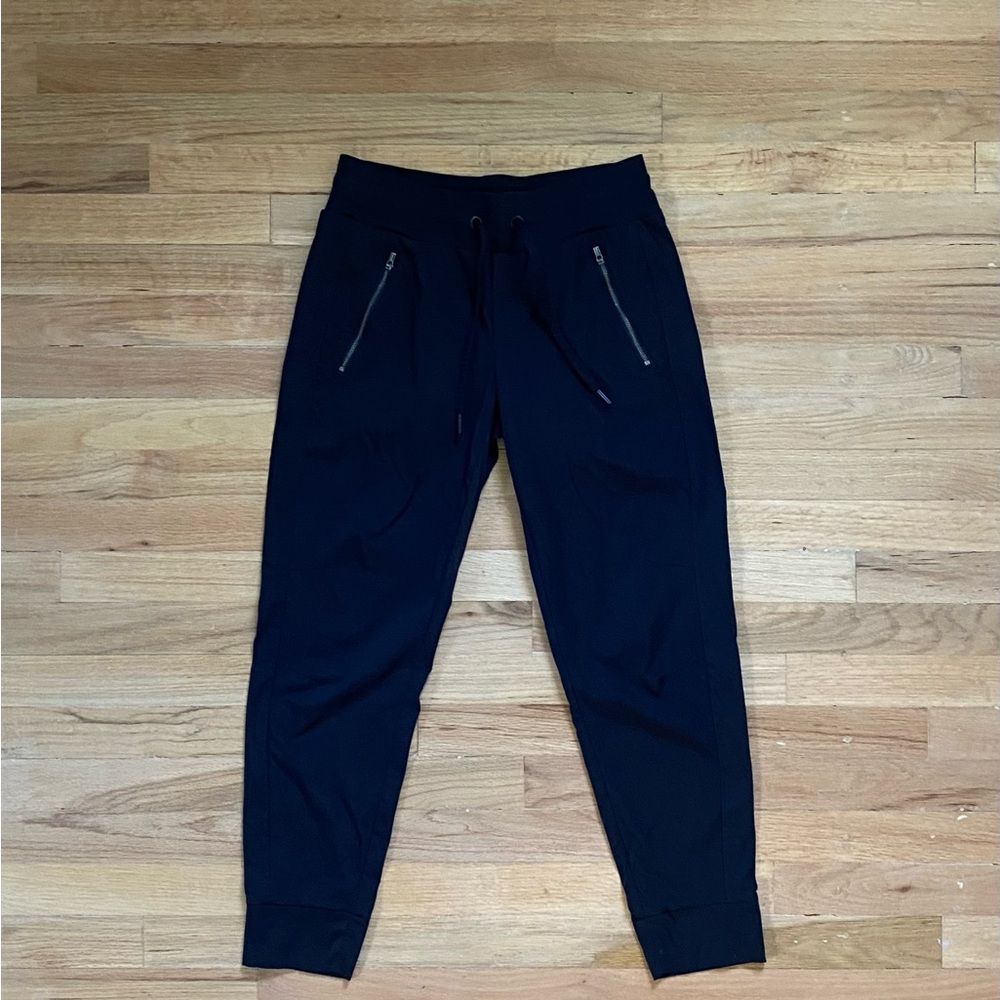 Athleta women’s black nylon joggers with zipper pockets.